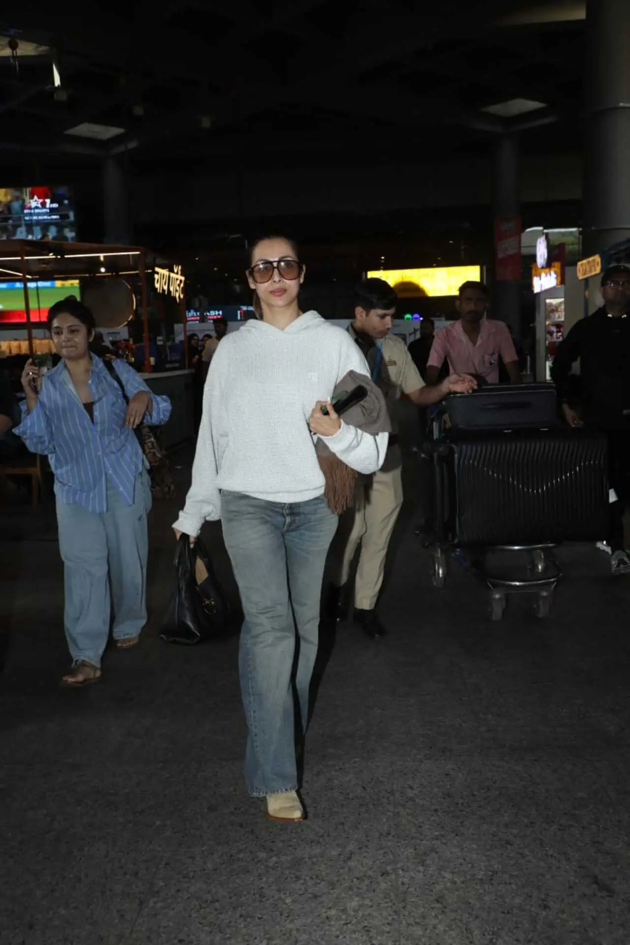 Malaika wore a comfy white hoodie paired with a bluish-grey pair of jeans. She completed her airport look with wide round sunglasses, a scarf and a stylish handbag.&nbsp;